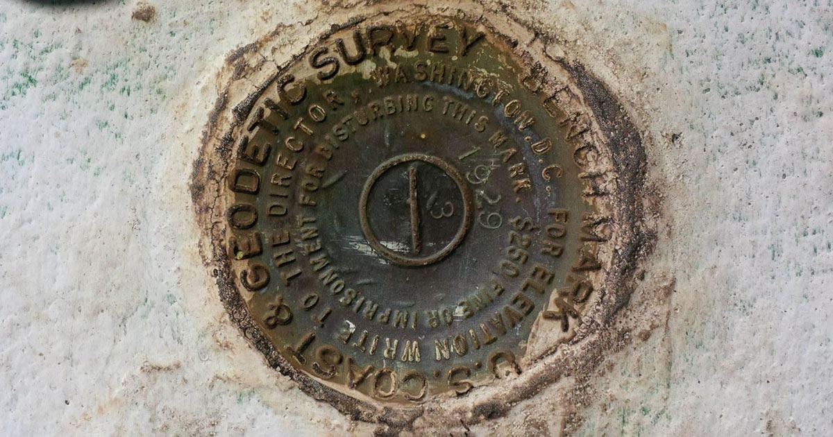 a circular rusty metal disc that marks the base of the Jupiter Inlet Lighthouse in Florida
