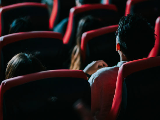 rear view asian chinese group of audience watching 3D movie in cinema enjoying the show with 3D glasses screaming excitement