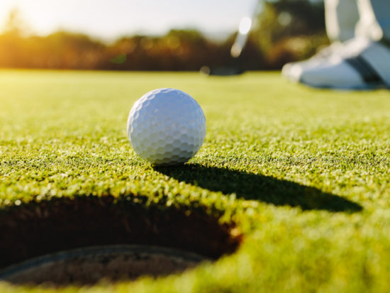 Professional golfer putting ball